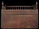 an old wooden bed with iron railings and a bird perched on top