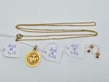 a close up of a gold necklace with a coin on it
