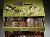 a green box with silverware in it on a table