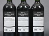 three bottles of red wine sitting on top of a table