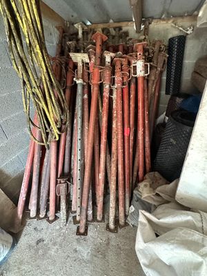 a pile of baseball bats and other items in a garage