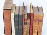 several old books are lined up in a row on a white surface