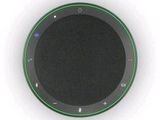 a close up of a black and green speaker on a white surface
