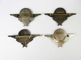 three old metal badges are displayed on a white surface