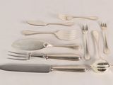 a lot of silverware on a table with a knife, fork, spoon, and spoon rest