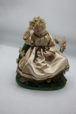 figurine en porcelaine représentant une femme assise sur une chaise avec un panier de fleurs