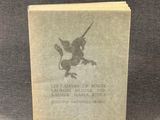 un vieux livre posé sur une table, à côté d'une photo en noir et blanc