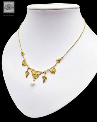 a white mannequin with a gold necklace on it