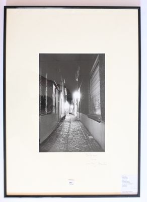 photographie en noir et blanc d'une rue étroite dans laquelle marche une personne