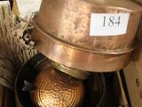 une boîte remplie de casseroles et de poêles posée par terre