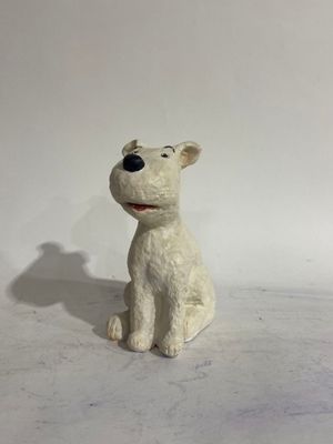 a small white dog figurine sitting on a white surface