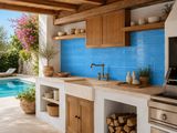 une grande cuisine en plein air avec une piscine en arrière-plan