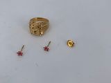 a close up of a gold ring and earring on a white surface