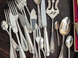 a lot of silver spoons and forks on a table