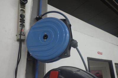 un tuyau bleu fixé sur le côté d'un mur