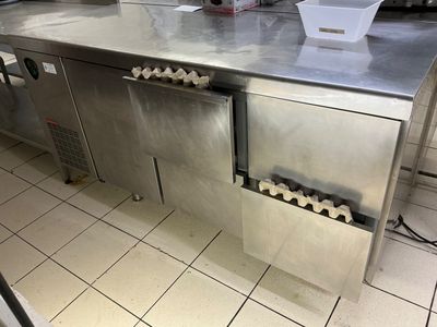 stainless steel counter top in a commercial kitchen with a bunch of bottles