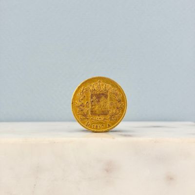 une pièce d'or posée sur une dalle de marbre