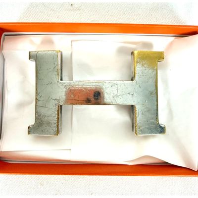une lettre « h » en métal dans une boîte posée sur une table