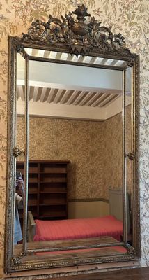 un miroir accroché au mur au-dessus d'un lit dans une chambre