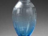 un vase en verre bleu posé sur un socle noir