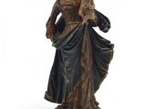 statue d'une femme tenant un enfant dans ses bras, posée sur un socle en bois