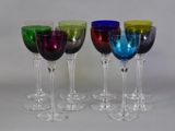 four wine glasses are lined up in a row on a table
