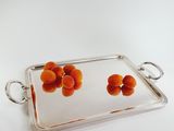 silver plated serving tray with orange fruit on it on a white surface
