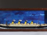 une image représentant une maquette de bateau dans un cadre en bois