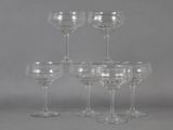 six clear wine glasses sitting on top of each other on a table