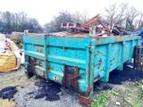 un camion-benne bleu qui est garé dans la poussière