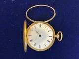 une montre de poche en or avec des chiffres romains