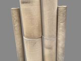 a group of four rolls of woven fabric on a gray background