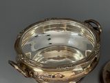 a silver bowl and a silver plate on a table