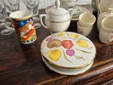 many plates and cups on the table with a cat on them