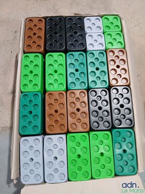 many different colored legos in a box on the floor