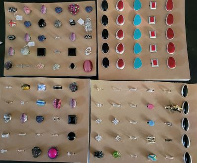 four pairs of earrings are displayed in a display case on a table