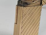 a gold lighter that is sitting on a white surface