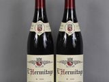 deux bouteilles de vin rouge posées sur une table en verre