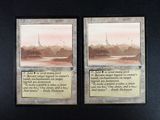 two cards on the table with a picture of a city in the background