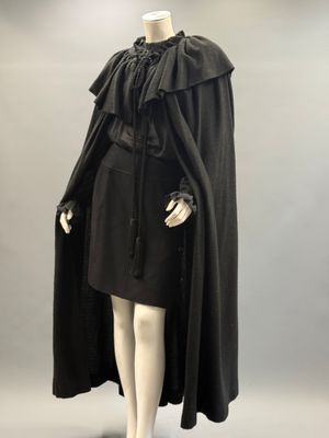 an image of a mannequin dressed in a black cape and dress