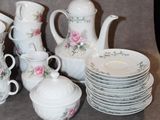 many plates and cups and a teapot on the table