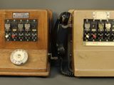 two old telephones sitting next to each other on a table