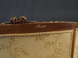 a close up of the back of a chair with a wooden frame