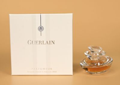 gros plan d'un flacon de parfum à côté d'une boîte