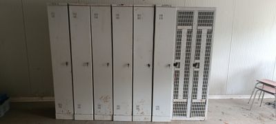 plusieurs casiers blancs dans une pièce équipée d'une table et d'une chaise