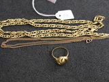 un gros plan d'une chaîne en or surmontée d'une bague
