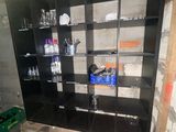 a black bookcase with many bottles of water on it