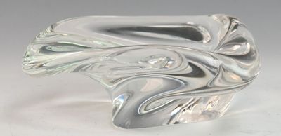 une sculpture en verre représentant une vague sur une surface blanche