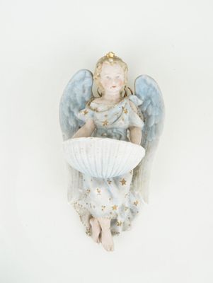une figurine représentant un ange assis sur une table