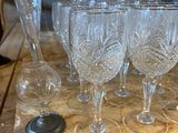 a lot of wine glasses sitting on a wooden table